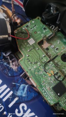 Zbliżenie na płytkę PCB z przylutowanymi przewodami i elektroniką