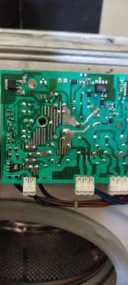 Płyta układu elektronicznego z wymienionym niebieskim komponentem, podłączona do pralki.