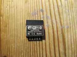 ESP-C2-02 module with Wi-Fi and Bluetooth on a wooden surface