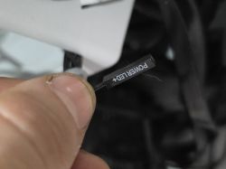 Zbliżenie na wtyczkę POWER LED+ trzymaną między kciukiem a palcem wskazującym