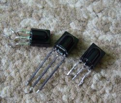 Three electronic receivers with three pins each, placed on a carpet.