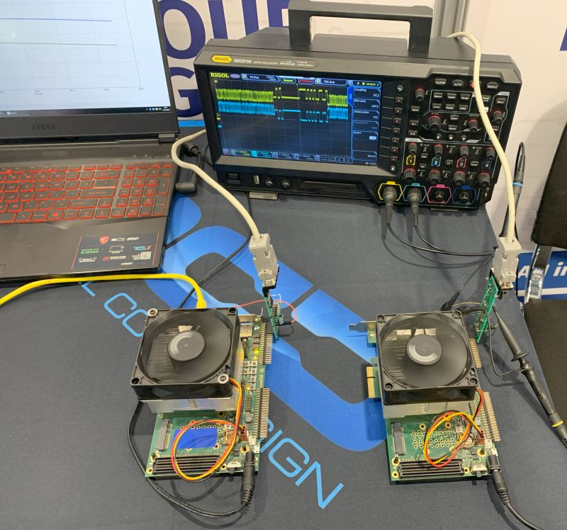 Oscyloskop Rigol i dwa układy elektroniczne z wentylatorami na wystawie.