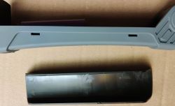 Części od lampki z otwartą szarą obudową i zdjętą czarną osłonką.