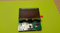 Shown is a display module mounted on a PCB with a green background.