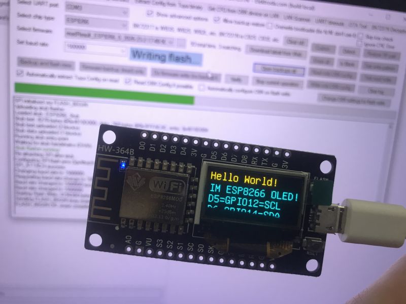 ESP8266 board with OLED showing “Hello World!”, connected via micro USB, in front of a flasher window