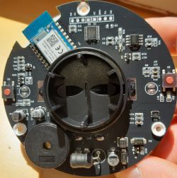 Round printed circuit board with Bluetooth module, various electronic components, and CR2032 battery holder.