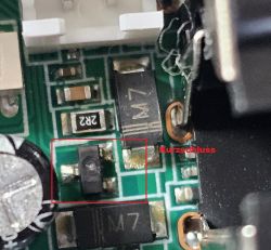 Nahaufnahme einer Leiterplatte mit rot markiertem SMD-Bauteil und dem Text „Kurzschluss“