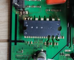 Zbliżenie na uszkodzony fragment płyty głównej lodówki Samsung RS68N8340B1 z widocznymi nadpaleniami i zniszczonymi elementami elektronicznymi.
