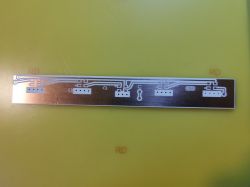 Double-sided PCB with etched traces and alignment holes on yellow background