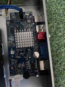 Zbliżenie na płytę główną komputera z widocznymi portami USB, kondensatorami i radiatorami.