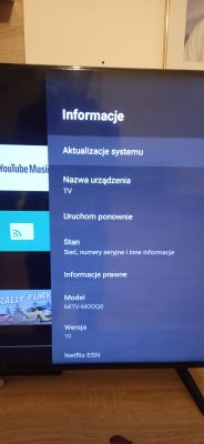 Telewizor marki Redmi z wyświetloną stroną ustawień systemowych i listą opcji menu.