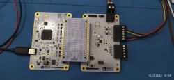 Płytki TMC8100 firmy Analog Devices połączone przewodami na niebieskim podłożu
