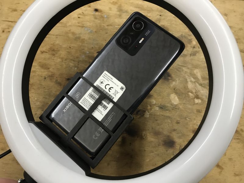 Phone held vertically in a 3D-printed mount attached inside a ring light