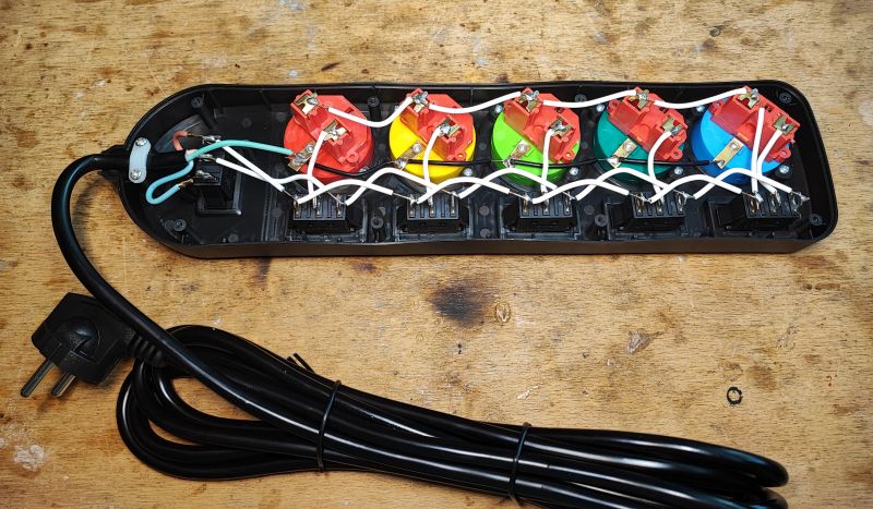 Widok wnętrza rozgałęźnika elektrycznego z wieloma kolorowymi włącznikami.