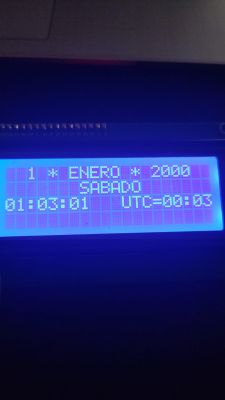 Niebieski ekran LCD z datą „1 ENERO 2000”, godziną i informacją o czasie UTC