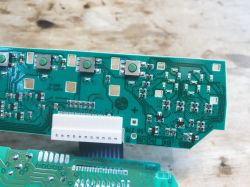 Widok zbliżony na płytkę PCB z przyciskami i elementami elektronicznymi z programatora zmywarki.
