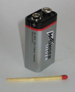 9V Wonder Silver battery standing next to a matchstick.