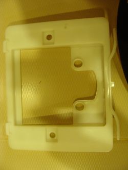 Plastic mounting frame for Cersanit button on a light background.
