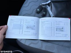 Car service book with inspection dates and car keys on a car seat.