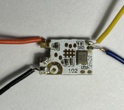Close-up of a small PCB with attached colored wires.