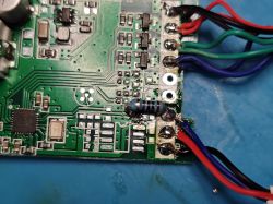 Close-up of a PCB with soldered colored wires and a striped resistor.