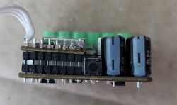 Smart Relay Module - Side View Close-up of a smart relay module showing electronic components, including capacitors and buttons.