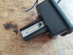 Close-up of an LED lighting device on a wooden surface.