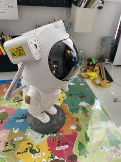 Zabawka w kształcie astronauty na mapie Polski, stanowiąca projektor gwiazd z laserem.