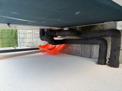 Rury instalacji zewnętrznej z izolacją termiczną przy elewacji budynku