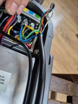 Zbliżenie na wnętrze sterownika z widocznymi kablami o różnych kolorach.