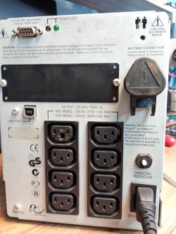 Panel tylni zasilacza UPS z gniazdami i informacjami technicznymi.