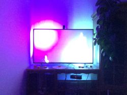 TV with colorful LED backlight glowing in purple and blue hues.