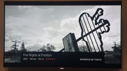 Czarno-biały obraz na telewizorze z napisem filmu Five Nights at Freddy's.