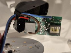 Zbliżenie na wnętrze rozebranego czujnika z widoczną płytką elektroniczną i okablowaniem.