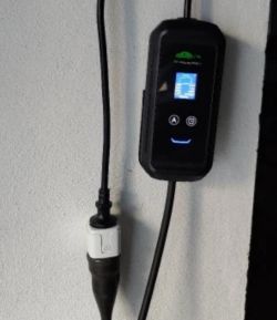 Wall-mounted EV charger with LCD screen and connected power cable