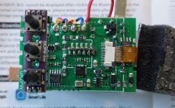 Close-up of a circuit board with buttons and various electronic components.
