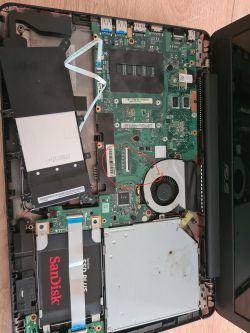 Wnętrze otwartego laptopa Asus model X554L z widoczną płytą główną.