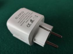 White ELVCO wall charger with EU plug on a green background, CE and RoHS markings visible