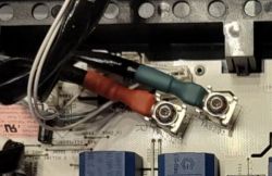 Zbliżenie na płytkę elektroniczną z przewodami i złączami.