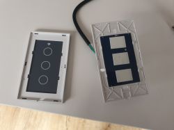The image shows a disassembled wall switch with three touch buttons and a circuit board.