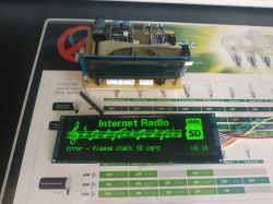 Electronic setup with a large OLED display showing an SD card error message.