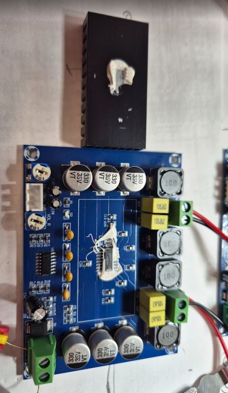 Audio amplifier circuit board with heatsink, capacitors, and an integrated chip
