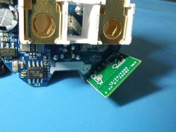 Electronics close-up: PCB with small attached module Close-up of a PCB with SMD parts and a small green add-on board labeled “CNZ‑0”.