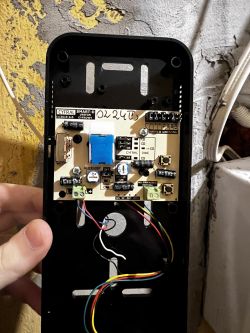 Zbliżenie na wnętrze domofonu z płytką obwodową Cyfral Smart-D z widocznymi przewodami i zworkami.