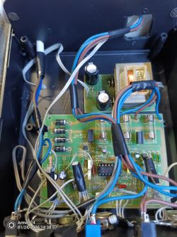 Wnętrze urządzenia elektronicznego z widoczną płytką PCB i okablowaniem