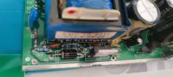 Zbliżenie na płytkę zasilacza elektronicznego z widocznymi elementami.
