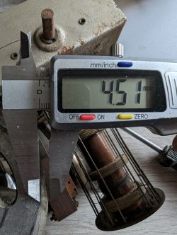 Wyświetlacz cyfrowego suwmiarki pokazujący wymiar 4.51 mm, na tle metalowych elementów.