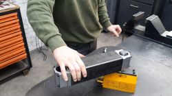 Magnetische Basis des Gewindebohrarms Person in grünem Pullover hält die magnetische Basis eines Gewindebohrarms.