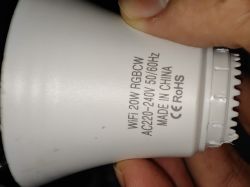 A white LED light bulb with technical information printed on it, held in a hand.