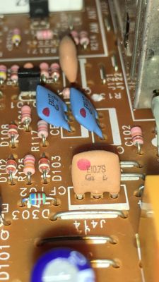Filtr ceramiczny oznaczony jako 10.7S zamontowany na płytce drukowanej obok innych komponentów elektronicznych.
